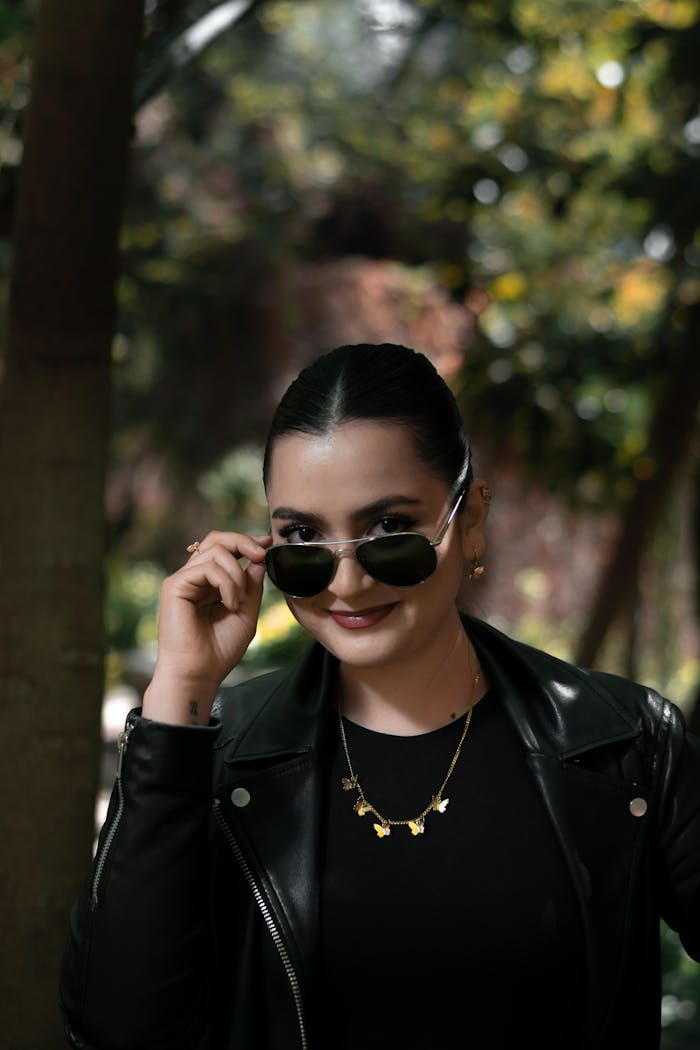 Services Elegant Caucasian woman outdoors in a leather jacket and sunglasses, exuding sophistication.