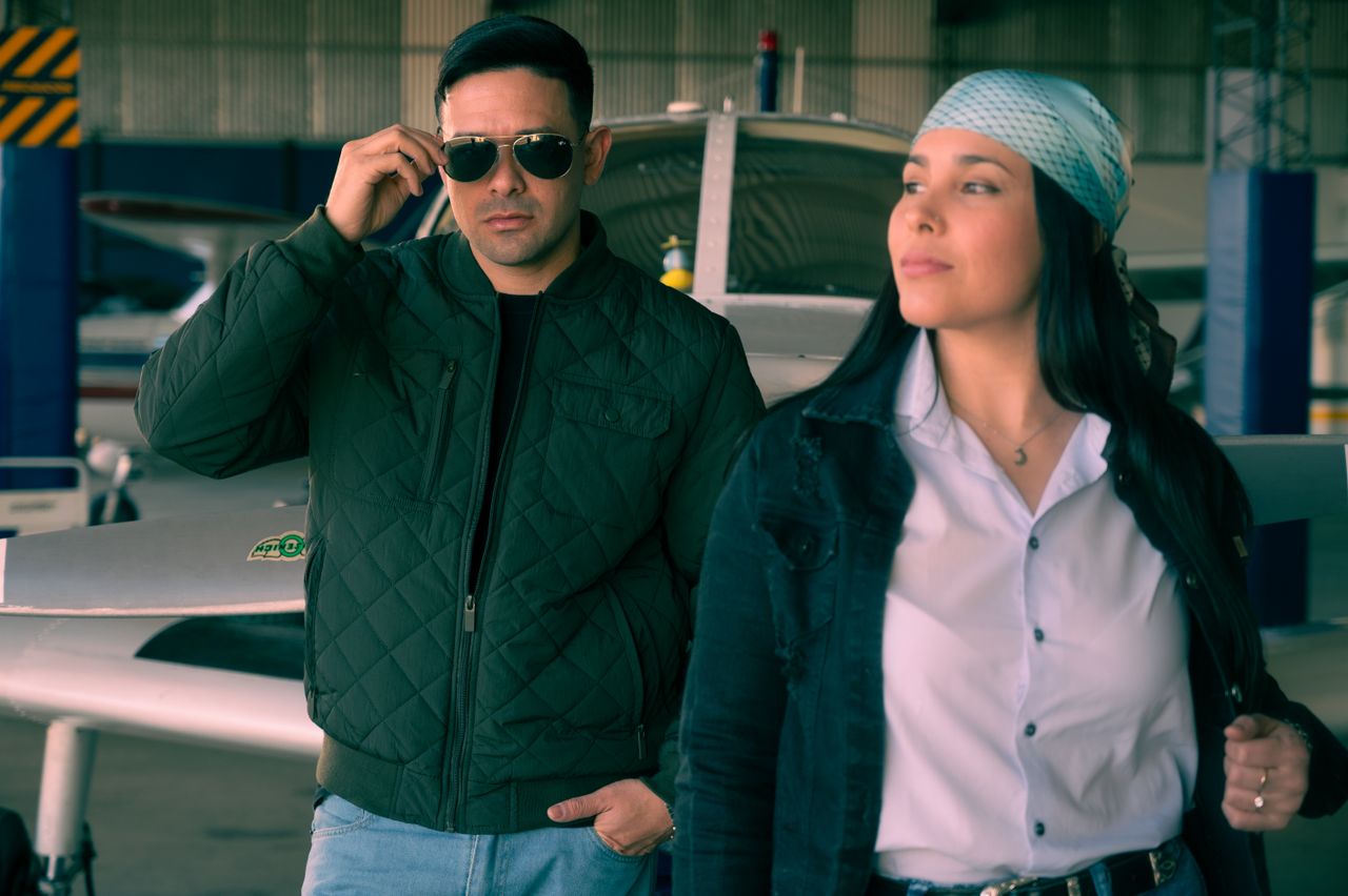 Services Two stylish individuals in an aircraft hangar, exuding confidence and coolness.